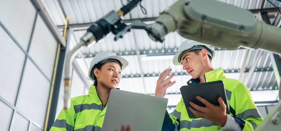 COLOUR-IMAGE_two-workers-wearing-hi-vis-coats-holding-devices_apr26